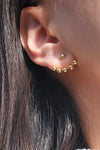 Ear jacket style earrings with a simple gold ball in the front and a row of five gold balls that peak out under your lobe from behind. 