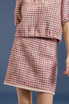 A women’s classic tweed mini skirt in berry colors with braided trim hemline.