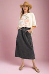 A women’s midi length, a-line,  elastic waisted cargo pocket skirt in a soft faded black denim.