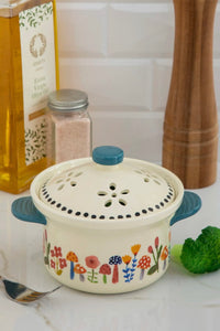 A ceramic, microwaveable vegetable steamer with colorful mushroom print.