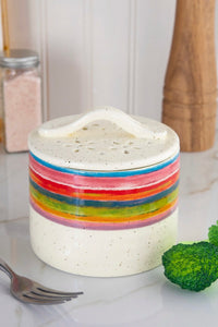 A rainbow colored, ceramic vegetable steamer for microwave.
