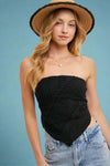 Model is wearing a black lace overlay tube top that has a triangle silhouette in the front. 