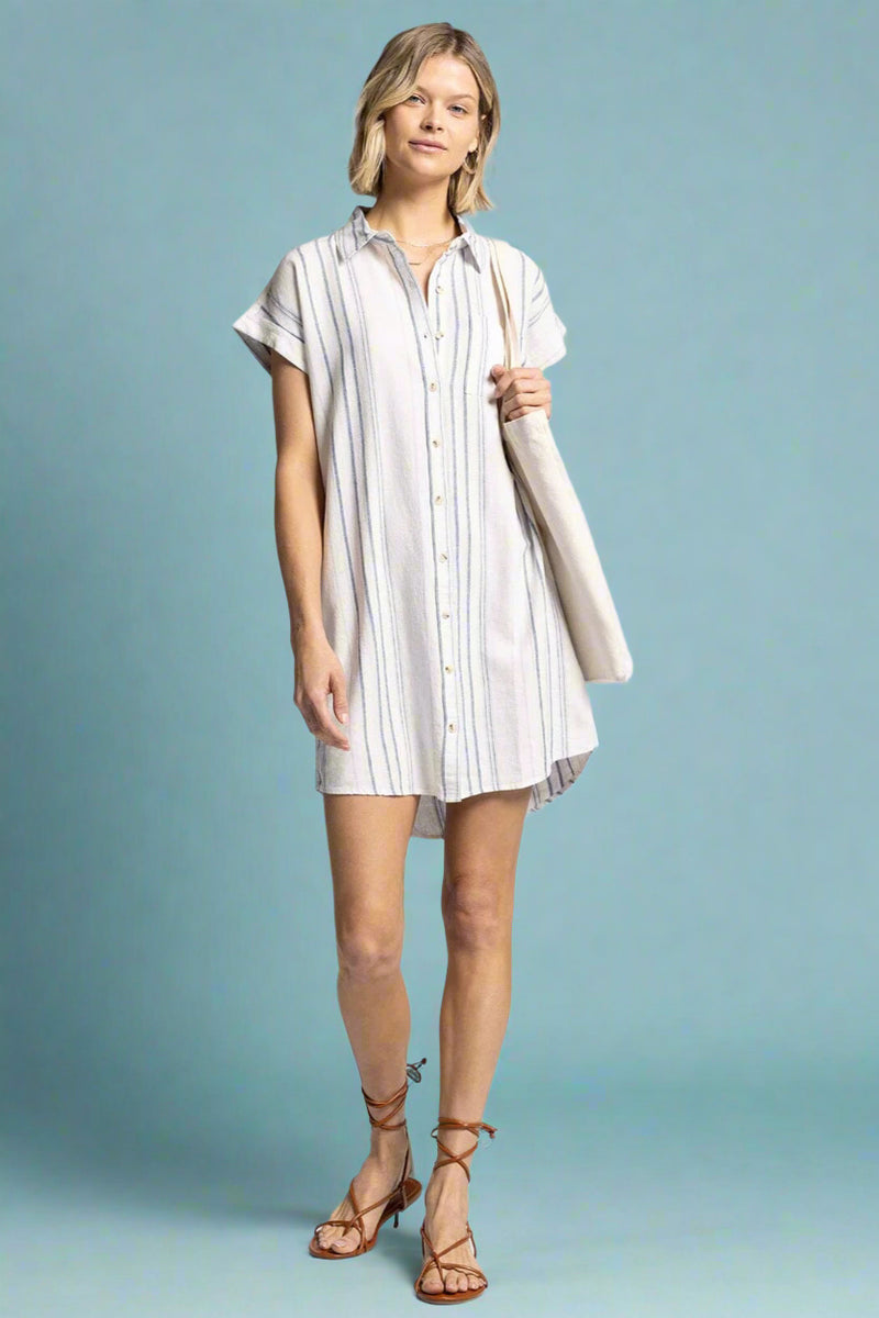 Model is wearing a drop shoulder linen blend striped shirt dress.