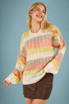 Model is wearing an oversized colorful striped crew neck sweater.