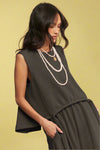 Model is wearing a soft knit high-low muscle tank with a front tie detail. 