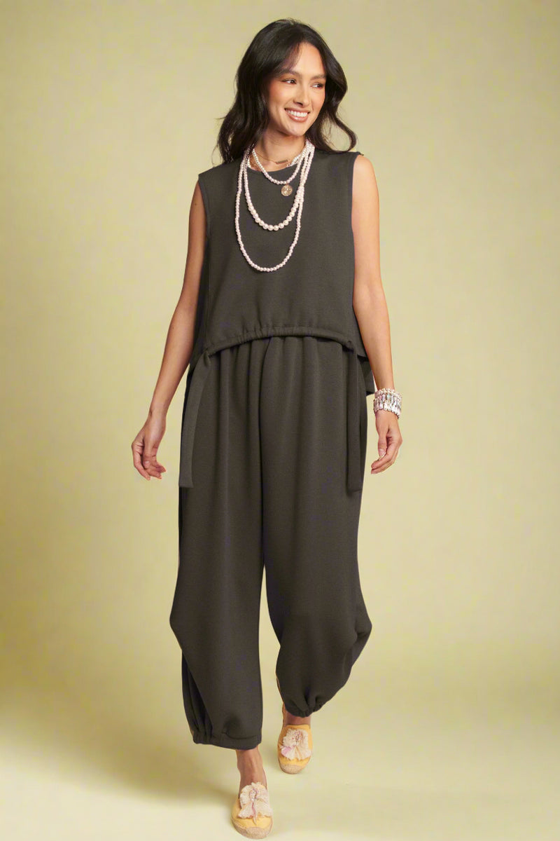 Model is wearing soft knit joggers that are a barrel silhouette  and synched on the bottom.