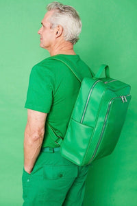 A green, vegan leather backpack with zipper closures and internal compartments.