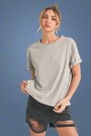 Woman wearing a gray t-shirt and black shorts on a beige background