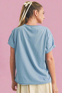 Person wearing a light blue t-shirt on a beige background