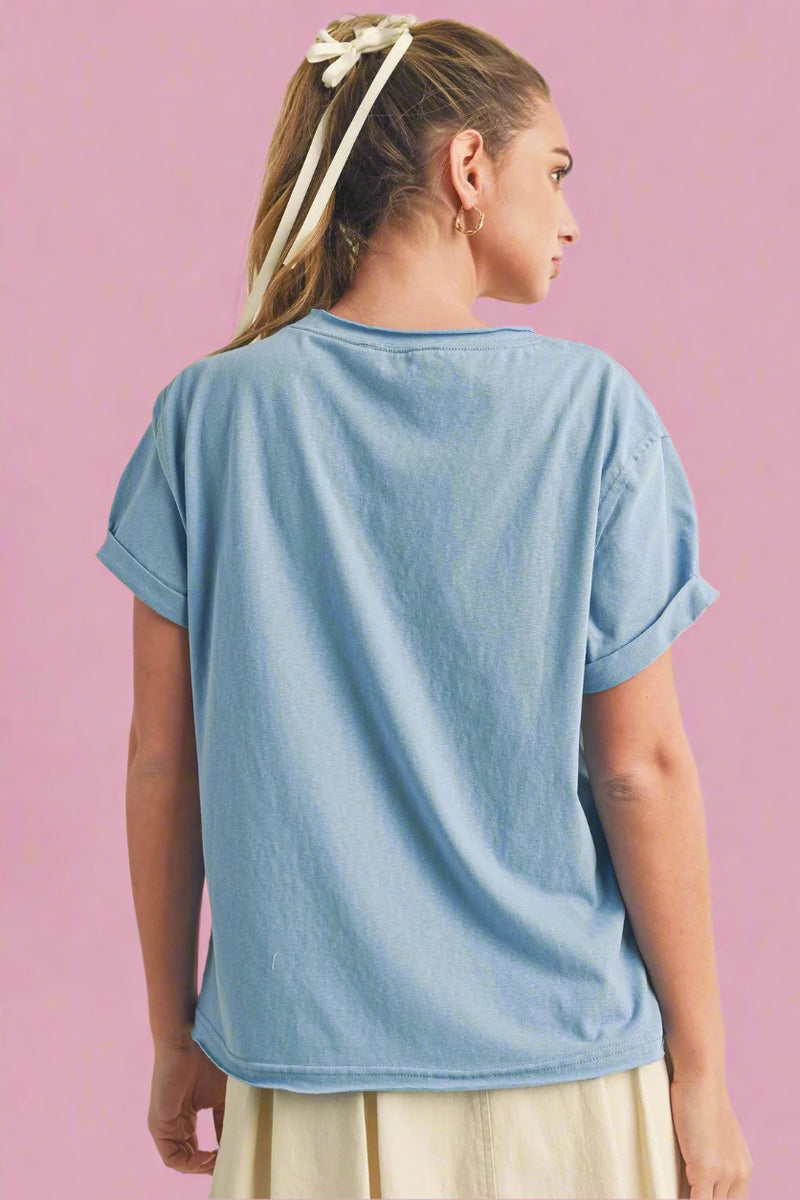 Person wearing a light blue t-shirt on a beige background