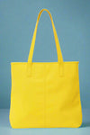 A yellow vegan leather tote bag with interior pockets.