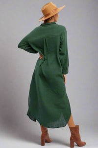 Person wearing a green dress and brown boots with a white background