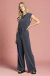 Woman wearing a gray jumpsuit on a white background