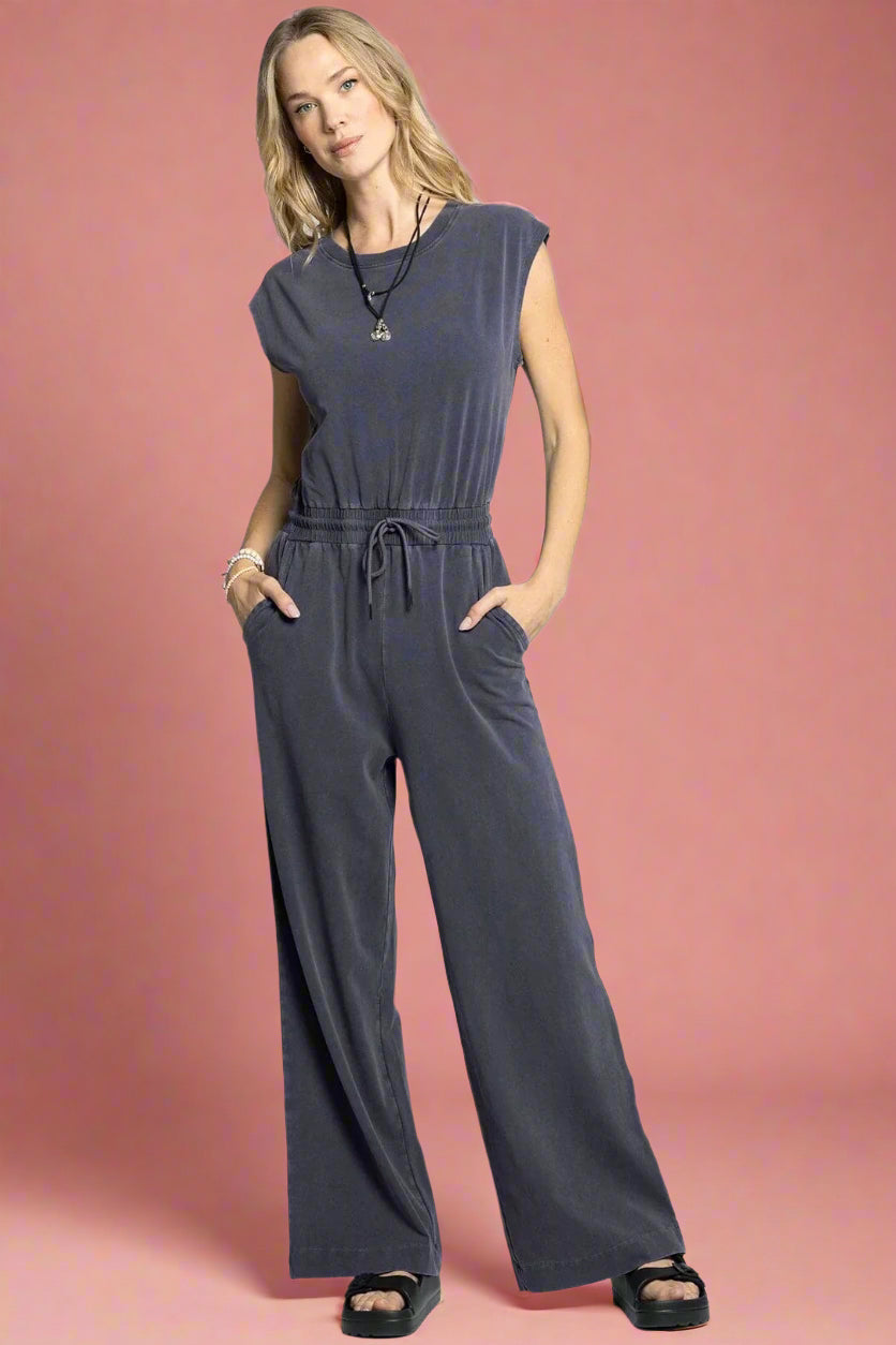 Woman wearing a gray jumpsuit on a white background
