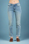 Model is wearing mid rise light wash colored boyfriend jeans that are cuffed on the bottom.