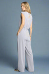 Woman wearing a light gray jumpsuit on a white background