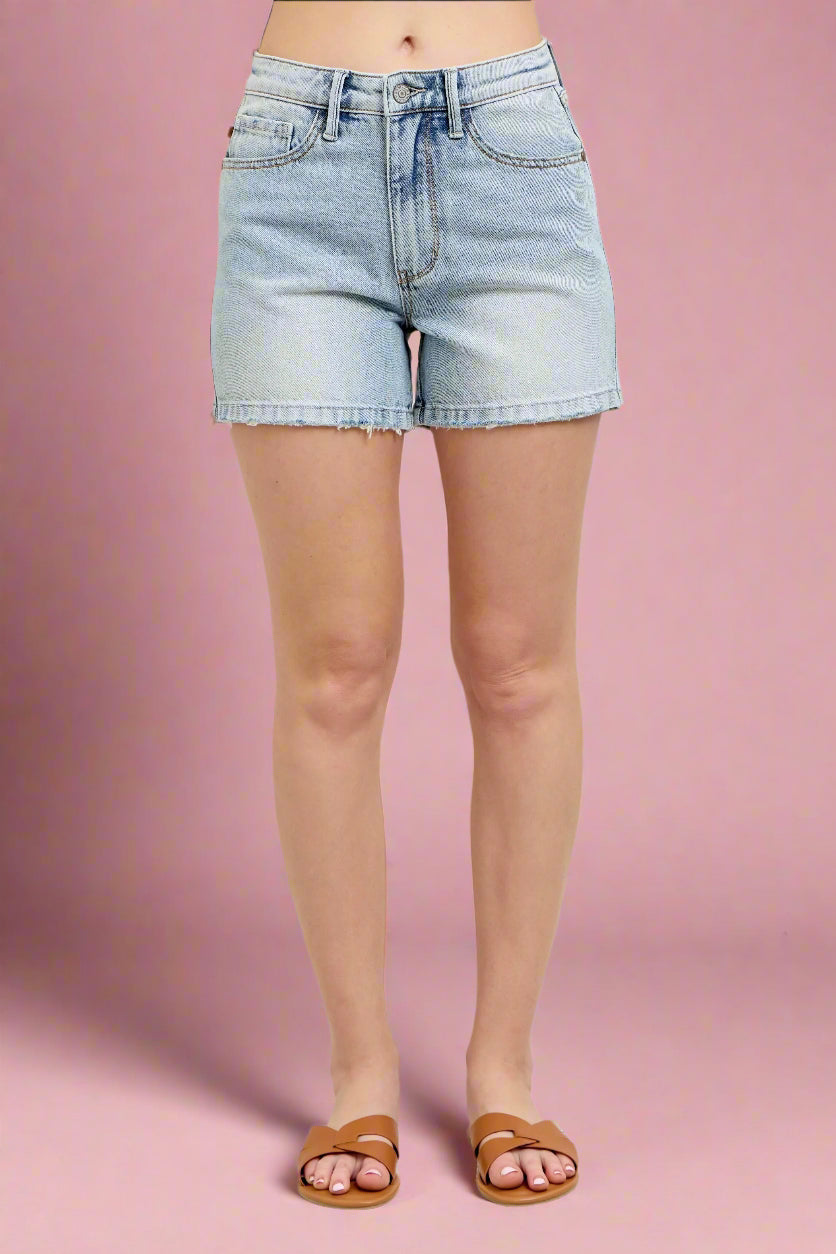 Model is wearing light wash vintage inspired denim shorts from Judy Blue. 