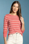 Woman wearing a red and white striped long-sleeve shirt against a plain background