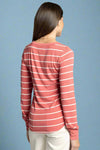 Woman wearing a pink and white striped long-sleeve shirt on a light gray background