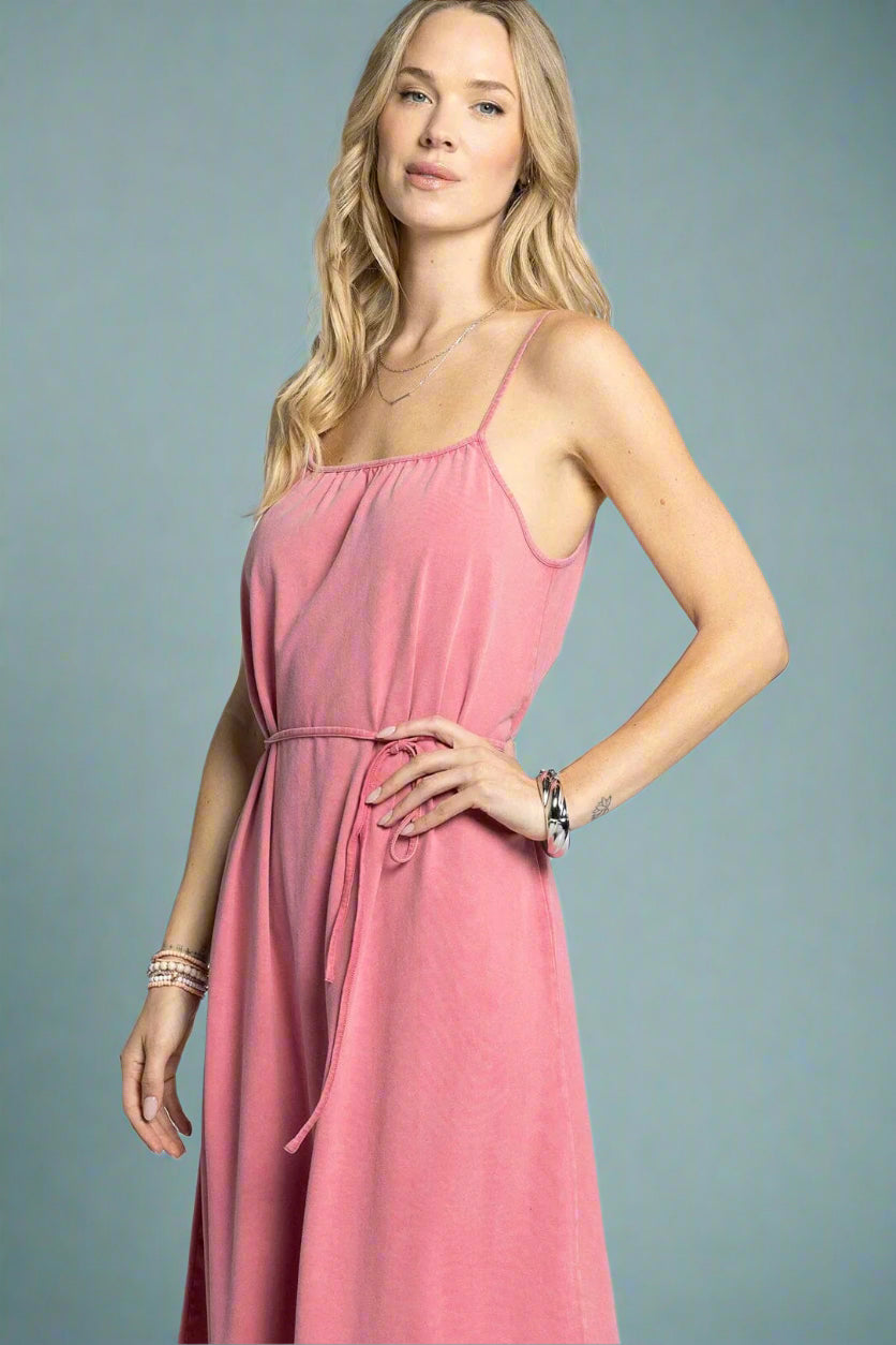 Woman wearing a pink dress against a light gray background