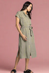 Woman wearing a green dress with a belt on a white background