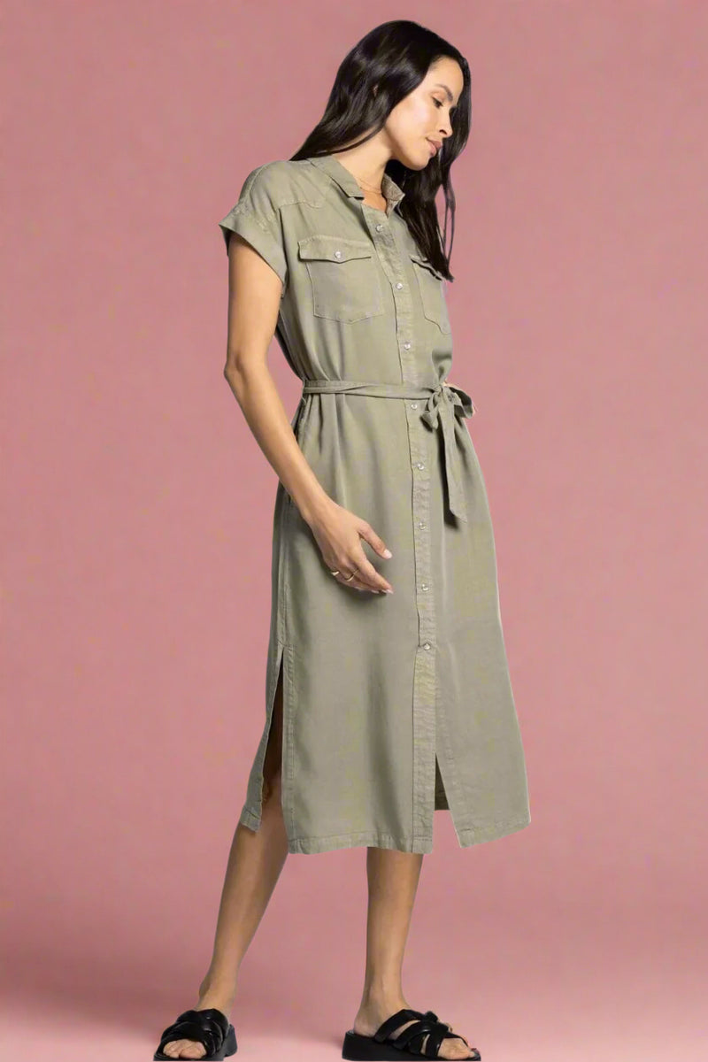 Woman wearing a green dress with a belt on a white background