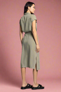 Woman wearing a green dress with a belt on a white background