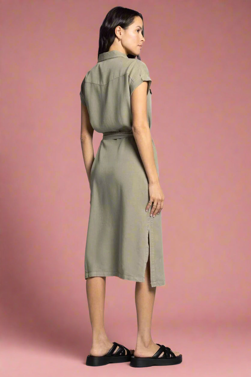 Woman wearing a green dress with a belt on a white background