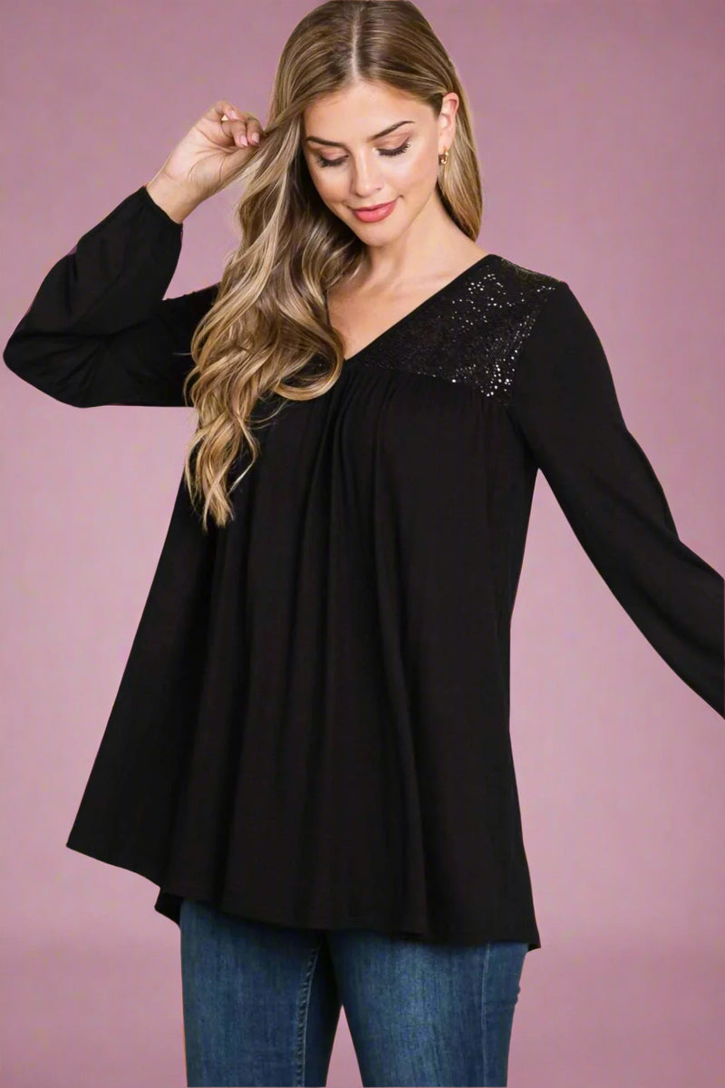 A long sleeve black tunic with sequin detail around the neckline.
