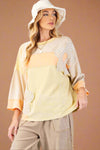 Model is wearing an oversized boho style patchwork top with dolman sleeves and flower embellishments. 