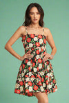 Model is wearing a floral printed sundress with an open back, scalloped trim detailing, and adjustable spaghetti straps. 