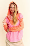 Model is wearing a two-toned heathered v neck hoodie with a hi-lo dolphin hem in bright orange and pink.