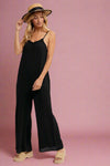 A black spaghetti strap jumpsuit. It has a ruffle neckline and wide legs.