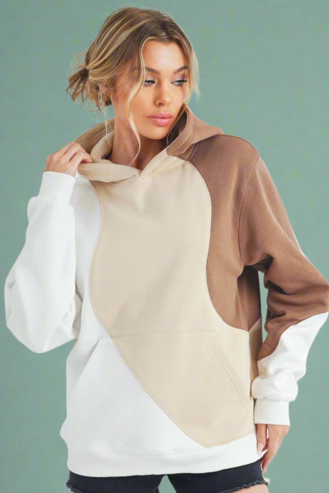 Model is wearing a classic hoodie with cute neutral color blocking in white, sand and brown. 