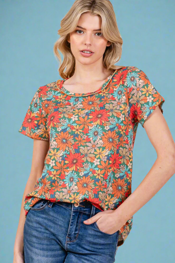 An exposed stitch hem, short sleeve tee with a retro floral pattern. It is lightweight and long in length.