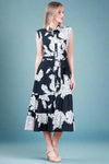 Woman wearing a black floral dress against a white background
