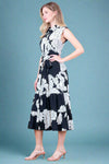 Woman wearing a black and white floral dress against a plain background