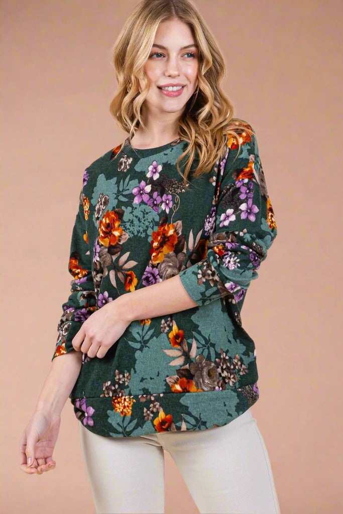 This lightweight sweater features an olive floral pattern. It has long sleeves and a drop shoulder.