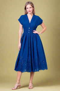 Woman wearing a blue dress against a white background