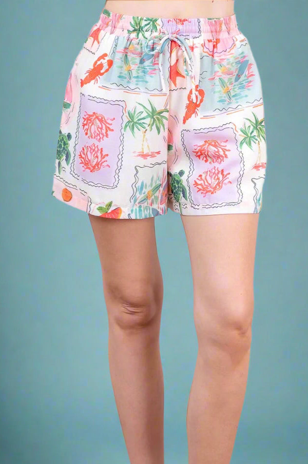 Shorts with a colorful floral pattern worn by a person on a solid background
