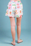 Shorts with a colorful floral pattern worn by a person indoors.
