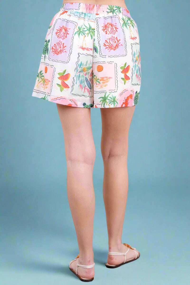 Shorts with a colorful floral pattern worn by a person indoors.