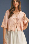 Woman wearing a pink lace top with double bow tie