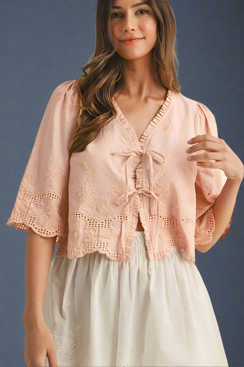 Woman wearing a pink lace top with double bow tie