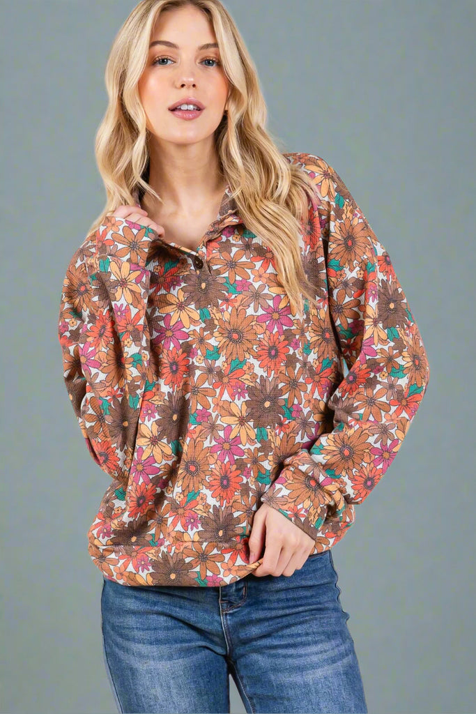 A long sleeve, quarter button pullover with a multi color retro floral print.