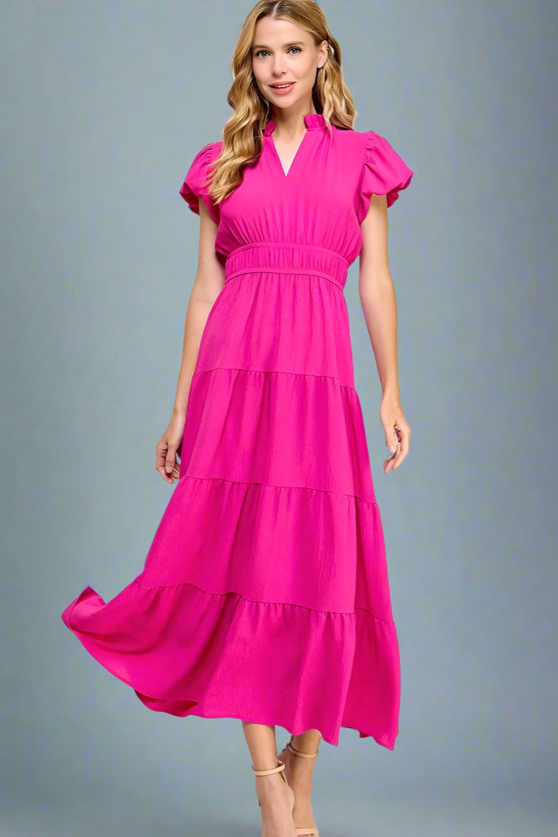 Woman wearing a bright pink short sleeve dress with elastic waist on a white background