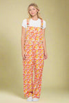 Model is wearing vibrant cotton overalls that are printed with a retro mushroom print.