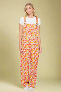 Model is wearing vibrant cotton overalls that are printed with a retro mushroom print.