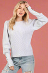 Long sleeve grey mineral washed waffle knit thermal with a puff sleeve and button detail on the cuff. 