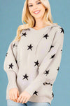 Model is wearing a hooded sweater in grey with black star pattern details. Featuring bell sleeves with ribbing and made from a super soft sweater-like material. 